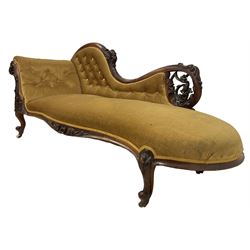 Victorian mahogany framed chaise longue, scrolled back and arm carved and pierced with scrolling vines and grapes with ribbon-twist mouldings, sprung seat and buttoned back upholstered in citrine velvet, apron moulded and carved with curling foliate decoration, on cabriole supports with ceramic castors