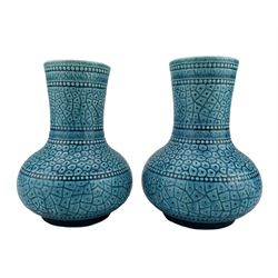 Pair of Burmantofts Faience turquoise-glaze vases, each of bulbous bottle form, beaded borders and incised ice ground, impressed factory marks beneath, model no. 35, H14.5cm & H15cm
