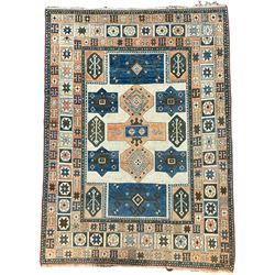 Antique Anatolian Turkish ivory ground carpet, field decorated with central peach geometric motif with surrounding stylised plant patterns within indigo borders, the multi-band border with repeating yildiz motifs