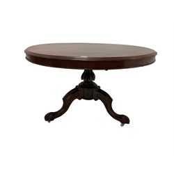 Victorian mahogany breakfast table, circular top with moulded edge and banded frieze, raised on a turned lobe bolster pedestal with tripod base, the scroll carved cabriole supports terminating in brass and ceramic castors