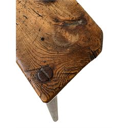 Early 19th century three-legged milking stool, figured elm seat on splayed tapering supports