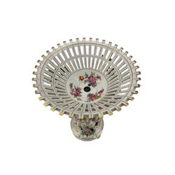 Continental porcelain centrepiece, the pierced basket form bowl painted and encrusted with flowers, the naturalistic stem modelled with a male and female figures, each in 18th century dress and picking flowers, the circular relief moulded base on four scroll supports, H45cm
