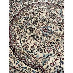 Persian Kashan ivory ground rug, the field decorated with star and floral medallion surrounded by trailing branch and stylised plant motifs, floral design spandrels and repeating border