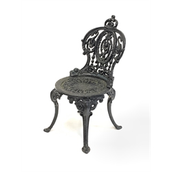 Victorian style heavy painted cast iron garden table, circular top with egg and dart rim over three supports topped by cast figures of Britannia (D70cm H72cm) and a pair of Coalbrookdale style cast iron garden chairs 