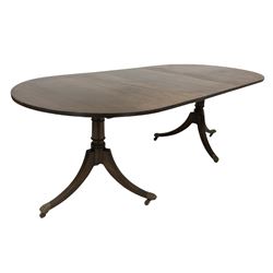Regency design twin pillar dining table, the oval top with chequered string inlay with one additional leaf, over turned columns and triple splay supports terminating in brass hairy paw cup castors 