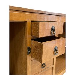 'Oakleafman' oak dresser base, all-over adzing, fitted with four short central drawers and two cupboards, wrought metal fittings, panelled doors and sides, the right-hand side carved with leaf signature, by David Langstaff of Easingwold