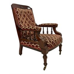 Late Victorian Aesthetic Movement mahogany open armchair, turned spindle arm supports, upholstered in buttoned foliate patterned fabric with sprung seat