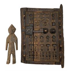 African Dogon  granary door heavily carved with stylised flowers etc 28cm x 22cm and a small carved wood African figure 19cm (2)
