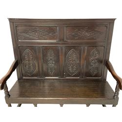 18th century carved oak high back settle, the two cresting horizontal back panels carved with concentric lozenges with central rosettes with extending foliage over four vertical panels carved with stylised anthemion leaves and acanthus and rose motifs, scrolled arm terminals over turned supports united by box stretcher