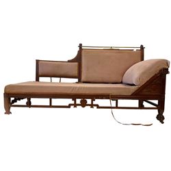 Aesthetic Movement mahogany framed chaise longue, brass cresting rail supported by lion masks, the back with reeded detail, apron pierced and carved with floral designs and Greek key pattern, raised on carved feet with castors, upholstered in pale pink textured fabric (W190cm D73cm H104cm); and pair matching armchairs, the back and and supports with geometric pierced and carved designs, stylised lotus carved to the apron (W65cm H99cm)