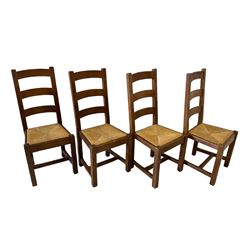 Set eight oak dining chairs, the ladder back over rush seat, raised on squared supports, united by H stretcher 