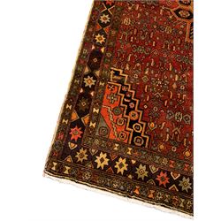 Persian Zanjan red ground rug, the central medallion with panels of stylised tree of life motifs, within a busy field of Herati motifs and matched spandrels, the dark indigo border with eight-pointed star motifs in alternating colours
