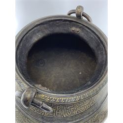 Large 19th century Indian bronze cauldron, the squat form body incised with stylized flowers and calligraphy on foliate ground, two large ring handles and three ring-shaped feet, H47cm x D53cm approx