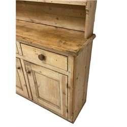 Rustic pine dresser, projecting cornice over two plate racks, the lower section fitted with two drawers and two panelled cupboards with wooden handles