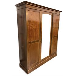 Edwardian mahogany triple wardrobe with all over chequered inlay, the bevelled mirrored door and panelled door enclosing interior fitted for hanging, flanked by another door enclosing drawers, raised on plinth base with recessed castors W177cm, H209cm, D57cm