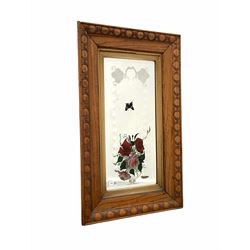 Early 20th century wall hanging mirror, the oak frame with egg and dart decoration enclosing an engraved bevel edged plate painted with floral bouquet 52cm x 82cm