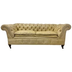 Early 20th century mahogany framed Chesterfield sofa, scrolled drop-arms, upholstered in light gold buttoned Damask floral pattern fabric with sprung seat, raised on turned feet with castors