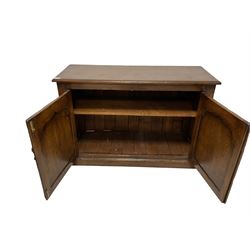 Oak two door cabinet, the rectangular top over two panelled doors with pointed arches, opening to reveal one adjustable shelf, raised on a plinth base 