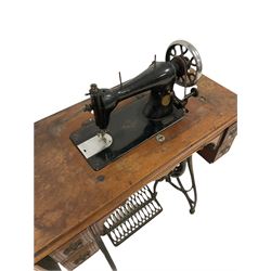 20th century Jones sewing machine, with cast iron treadle base, terminating in castors