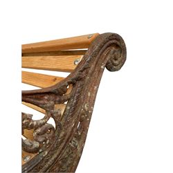Victorian cast iron and oak slatted garden bench, the bench ends decorated with pierced foliage scrolling and trailing rope, on splayed feet with foliate scroll terminals, polished light oak slats 