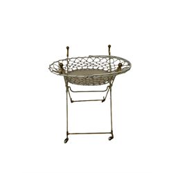 Late 19th century case containing brass and cream painted iron crib and bassinet by The Universal Folding Basket, together with an assortment of clothing, including letter from titled estate from Whitby