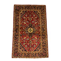 Persian red ground rug, the central indigo pole medallion surrounded by stylised plant motifs and matching spandrels, the guarded border decorated with repeating floral designs