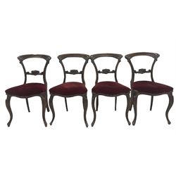 Set four Victorian dining chairs with scroll carved cresting rail and back rail, over seats upholstered in red fabric, raised on cabriole legs 
