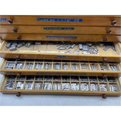 A six drawer printers chest containing a quantity of metal stamps/ matrices and other accessories, H25cm, W51cm, D25.5cm