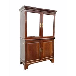 Georgian mahogany press, projecting cornice over two mirrored doors, two panelled doors under enclosing shelves, with slide raised on bracket supports W118cm, H185cm, D54cm this item has been converted for use as a drinks cabinet