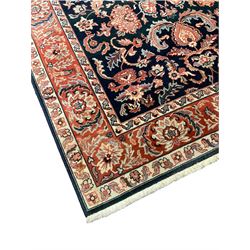Persian design coral and blue ground rug, the field decorated with stylised flower and foliate patterns, triple band border decorated with repeating flowerhead and plant motifs
