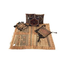 Middle Eastern flatweave and tufted brown ground rug with a cross design, (124cm x 132cm) together with two Persian saddle bags, and three cushions in Kilim type covers 