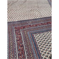 Large Persian Araak red ground carpet, the ivory field decorated with conforming boteh motif, enclosed by multi line border 355cm x 272cm