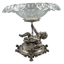 French silver-plated centrepiece by Christofle, modelled as a reclining cherub supporting the circular cut glass bowl with flared petal rim, the circular base cast with trailing foliage on four swept feet, stamped Christofle, H23cm x W25cm 