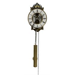 A German 20th century chain driven hanging wall clock with a visible skeletonised movement and 6” open dial, with Roman numerals and pierced steel hands, chain driven movement with a recoil anchor escapement and hourly passing strike on a brass  bell, with a gilt brass cased weight and pendulum. 
