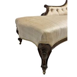 Victorian mahogany framed chaise longue, curved moulded frame carved with scrolled foliage, upholstered in buttoned champagne fabric, on cabriole front feet with scrolled terminals, brass castors