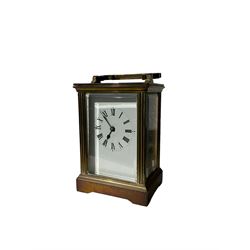 Early 20th century 8-day French carriage clock - with an anglaise case carrying handle and bevelled glass panels, white enamel dial with Roman numerals, minute markers and steel spade hands, jewelled platform lever escapement, balance with timing screws. 