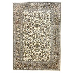Persian Kashan ivory ground carpet, the field decorated with all-over palmettes interlaced with scrolling branches and foliage, the guarded border with floral patterns entwined with extending leafage and flower heads