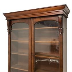 Victorian mahogany bookcase on cupboard, projecting cornice over two glazed doors enclosing shelves, mounted by scroll and acanthus carved brackets, fall front drawer over panelled double cupboard, on chamfered plinth base 