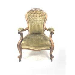 Victorian walnut open armchair, with floral carved crest rail over button upholstered back rest, scrolled arm terminals, raised on cabriole front supports terminating in ceramic castors 