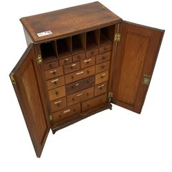 Small 19th century mahogany collector's cabinet, moulded rectangular top with quarter-matched veneers and satinwood band, two panelled doors enclosing a combination over small drawers, on bracket feet