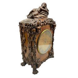 A  19th century carved walnut bracket clock and associated bracket,  case carved with representations of entwined vine leaves and grapes, surmounted by a sleeping putto, case on four carved paw feet, with an eight- day five-pillar twin fusee movement, recoil anchor escapement striking the hours on a bell, rectangular movement plates with curved shoulders and decorative plate work, movement back plate and dial inscribed   “ Patent Detached Lever, Griffiths , London”, nine-inch formerly silvered brass dial and steel moon hands, with engraved Roman numerals and minute markers, flat glass within a spun brass bezel and silvered sight ring, with an old trade label for G Spiegelhalter, 6 The Mount, Whitechapel Road, London.  With pendulum.
Clock case  H 63 W 36 D 22
Bracket W 46 D 26

