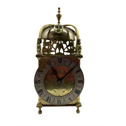 A 20th century spring driven table clock in the style of an early 17th century Lantern clock, with an eight-day striking movement and lever platform escapement, striking the hours and half hours on a bell, with a 5” silvered chapter ring, Roman numerals, half hour markers and quarter hour division track.


