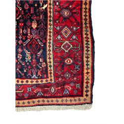 Persian indigo ground rug, the central crimson geometric medallion banded by repeating lozenges, the field decorated profusely with interlacing geometric motifs, the guarded border with stylised plant patterns