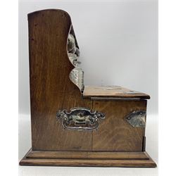 Edwardian oak three-bottle tantalus with silver-plated strapwork mounts, shield shaped plaque and swing handles, containing three later cut glass square form decanters, two hinged doors with fitted interior and secret drawer beneath, L37cm, H33cm, D29cm 