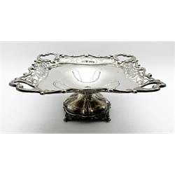 Square silver fruit dish with a pierced floral and scroll border on a pedestal foot 20cm square Sheffield 1912 Maker Elkington & Co. 15oz
