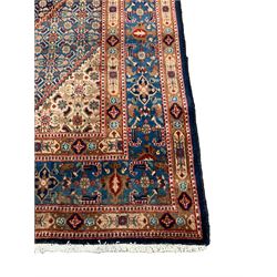 Persian Mood indigo ground rug, the field in the form of stepped lozenges and decorated with repeating floral Herati motifs, the main border decorated with further Herati motifs with guard bands