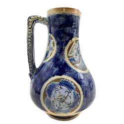 Robert Wallace Martin for Martin Brothers, a stoneware jug, 1876, incised and painted with stylized leaves in roundels on a geometric blue ground, inscribed 67* RW Martin London 5-1876, H24cm