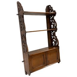 Late 19th century walnut wall hanging bookcase, fitted with two shelves and double panelled cupboard, fretwork end supports decorated with scrolling foliage 