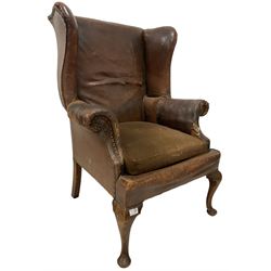 Wingback armchair, upholstered in brown leather, raised on cabriole supports 