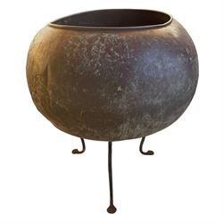 19th century globular copper chocolate pot or garden planter of large proportions, raised on a later wrought metal tripod stand with three shaped splayed supports with pad feet 